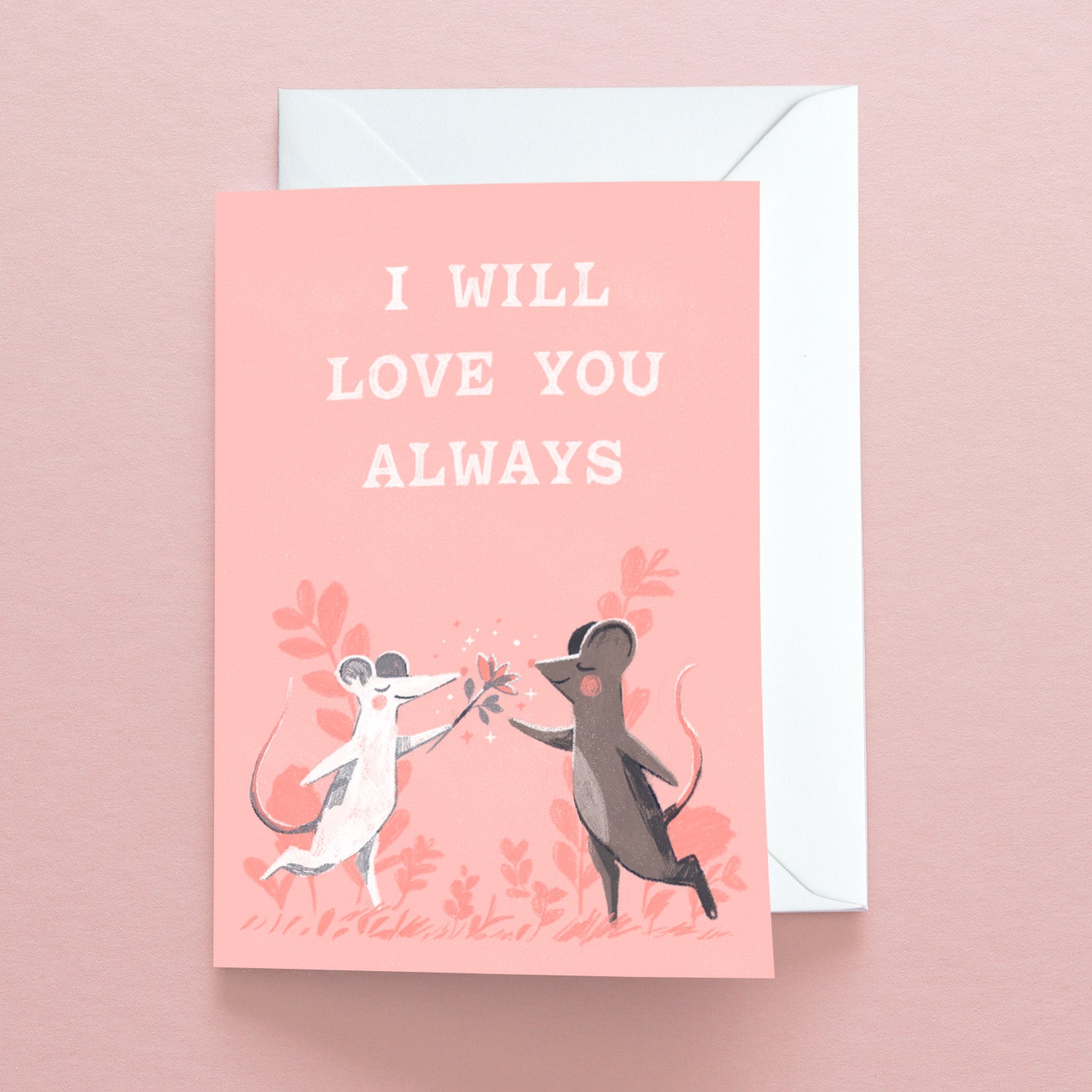 The I Will Love You Always Mice Greetings Card by Papio Press is printed on recycled stock. This pink card shows two cartoon mice touching noses, holding a flower, with “I WILL LOVE YOU ALWAYS” in white text above them.