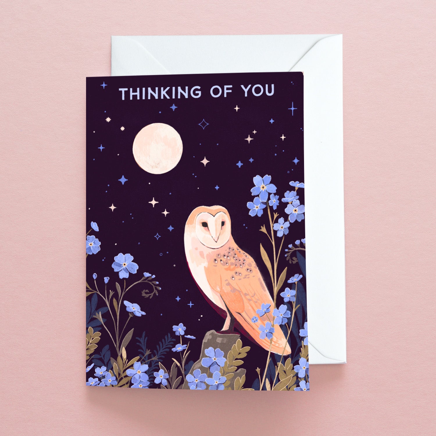 The Papio Press Thinking of You Owl Greetings Card features a barn owl among blue flowers under a full moon and starry sky on pale pink, finished with THINKING OF YOU and printed on recycled stock for an eco-friendly touch.