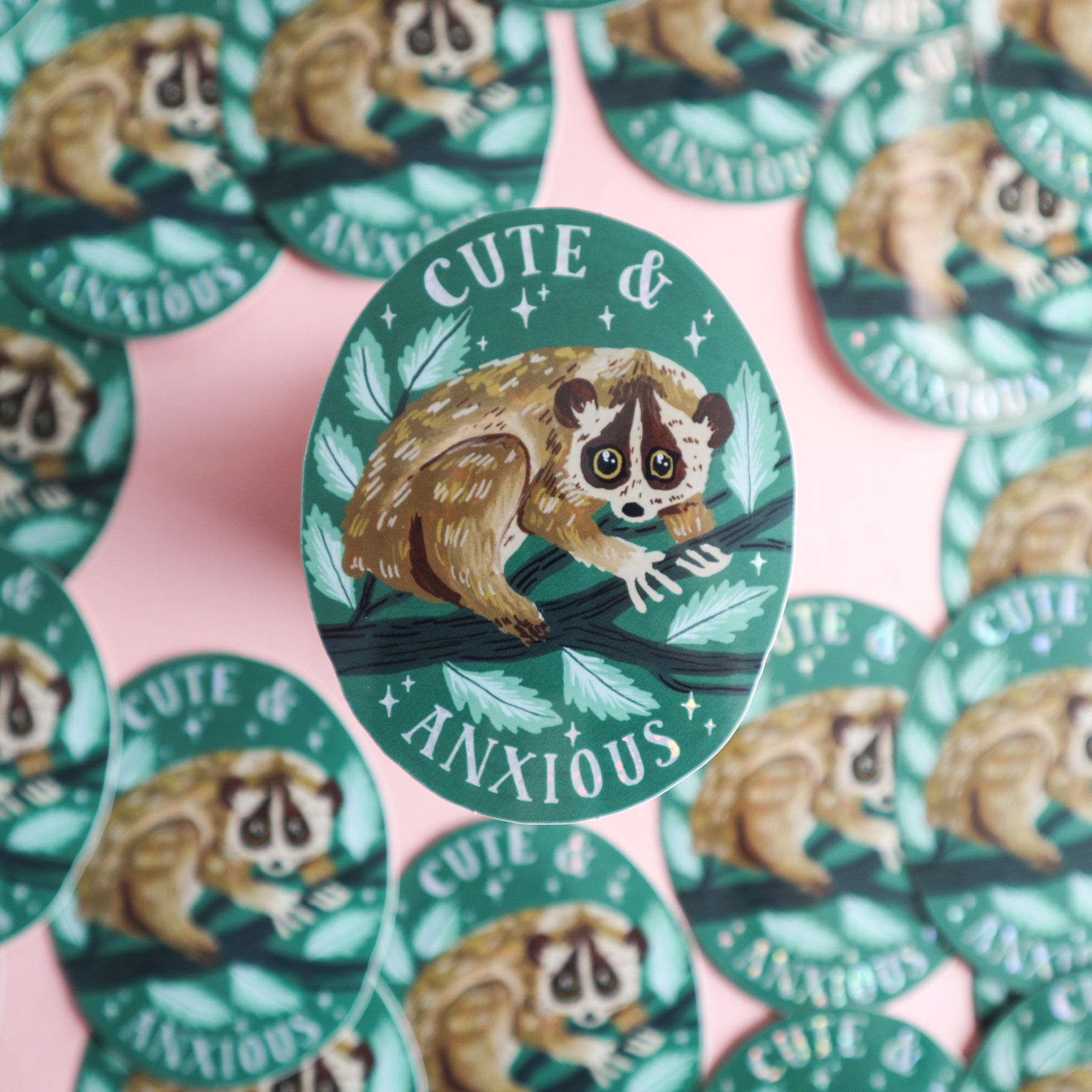 Papio Press’s Cute & Anxious Slow Loris Sticker is a round, glossy vinyl design showing a wide-eyed loris on green leaves with the caption “CUTE & ANXIOUS,” perfect for adding shine and charm to any surface.