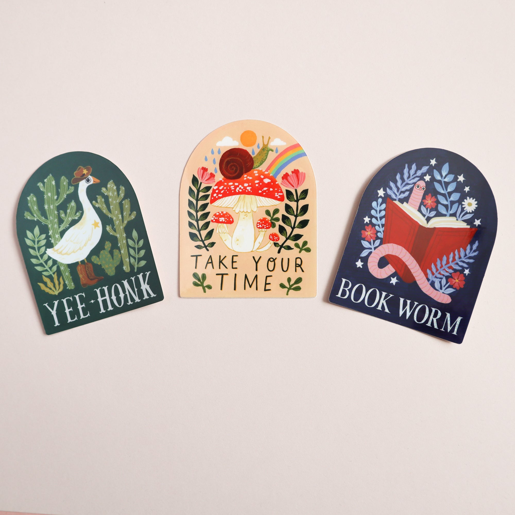 Papio Press Set of Three Stickers: Book Worm, Yee-Honk, & Take Your Time—illustrated glossy stickers with UV protection. Features a goose with cacti (YEE HONK), mushroom and snail (TAKE YOUR TIME), and open book (BOOK WORM).