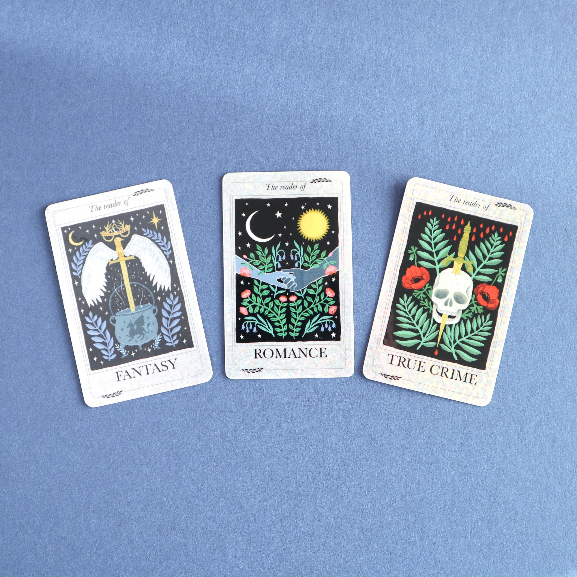 Papio Press’s The Reader of True Crime Sticker set features three glittery vinyl tarot-style cards: Fantasy (sword and crown), Romance (hands and moon), and True Crime (skull and roses)—a unique, eye-catching accessory.