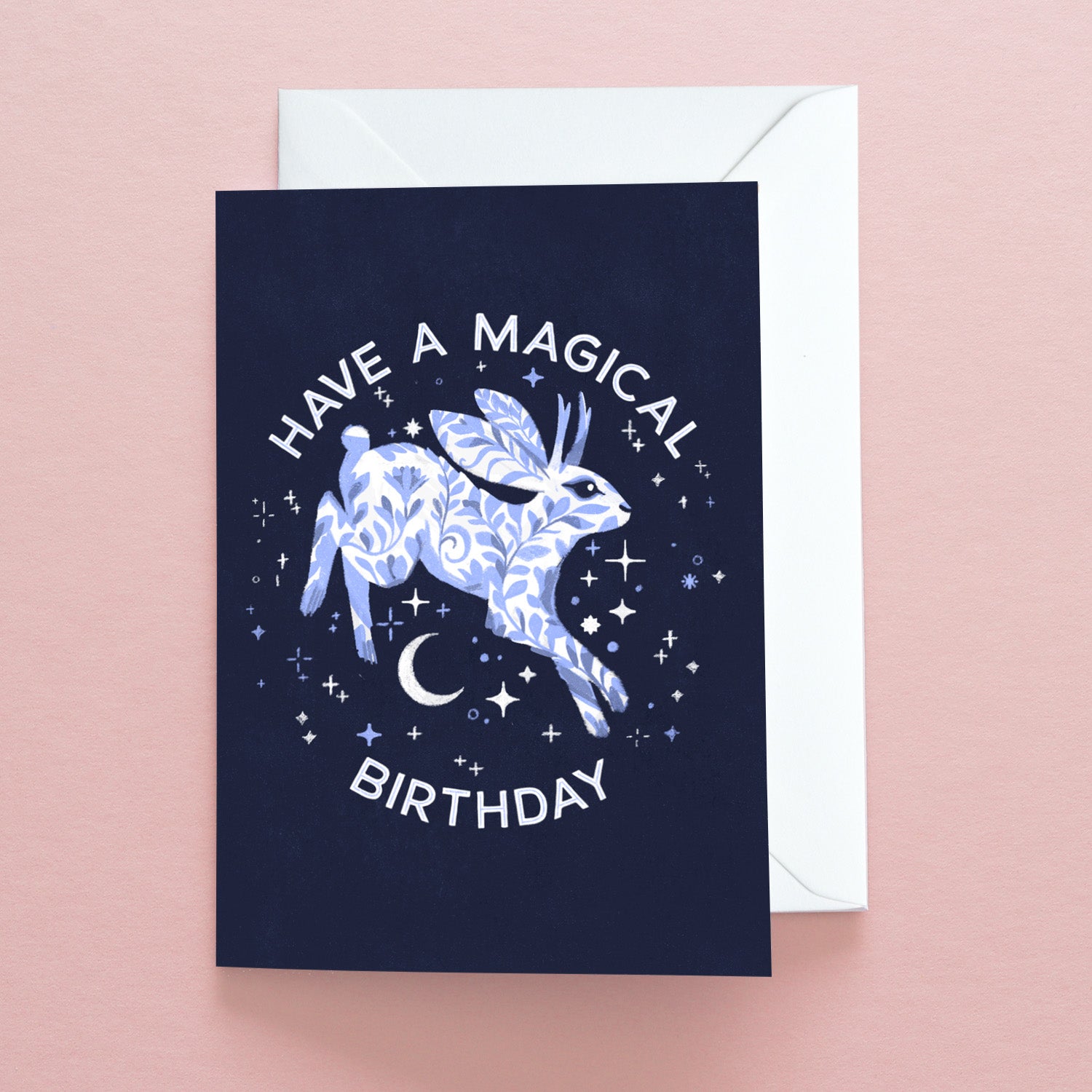 The Have a Magical Birthday Jackalope Greetings Card by Papio Press features a mystical jackalope amid stars and a crescent moon, with white text on dark blue. Printed on recycled stock and supplied with a white envelope.
