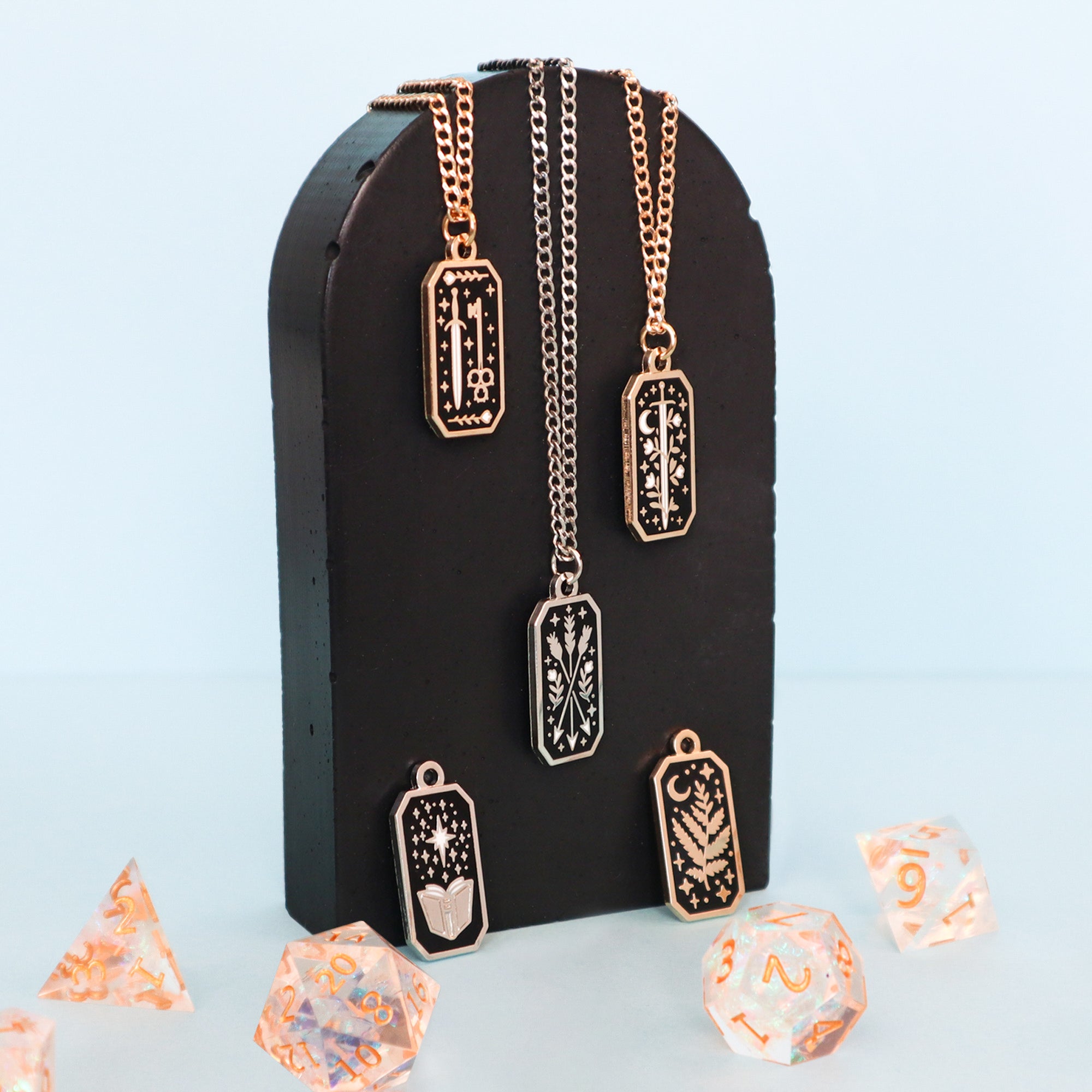 A selection of Papio Press Fantasy necklaces on a black plinth. Taken on a muted grey background. 