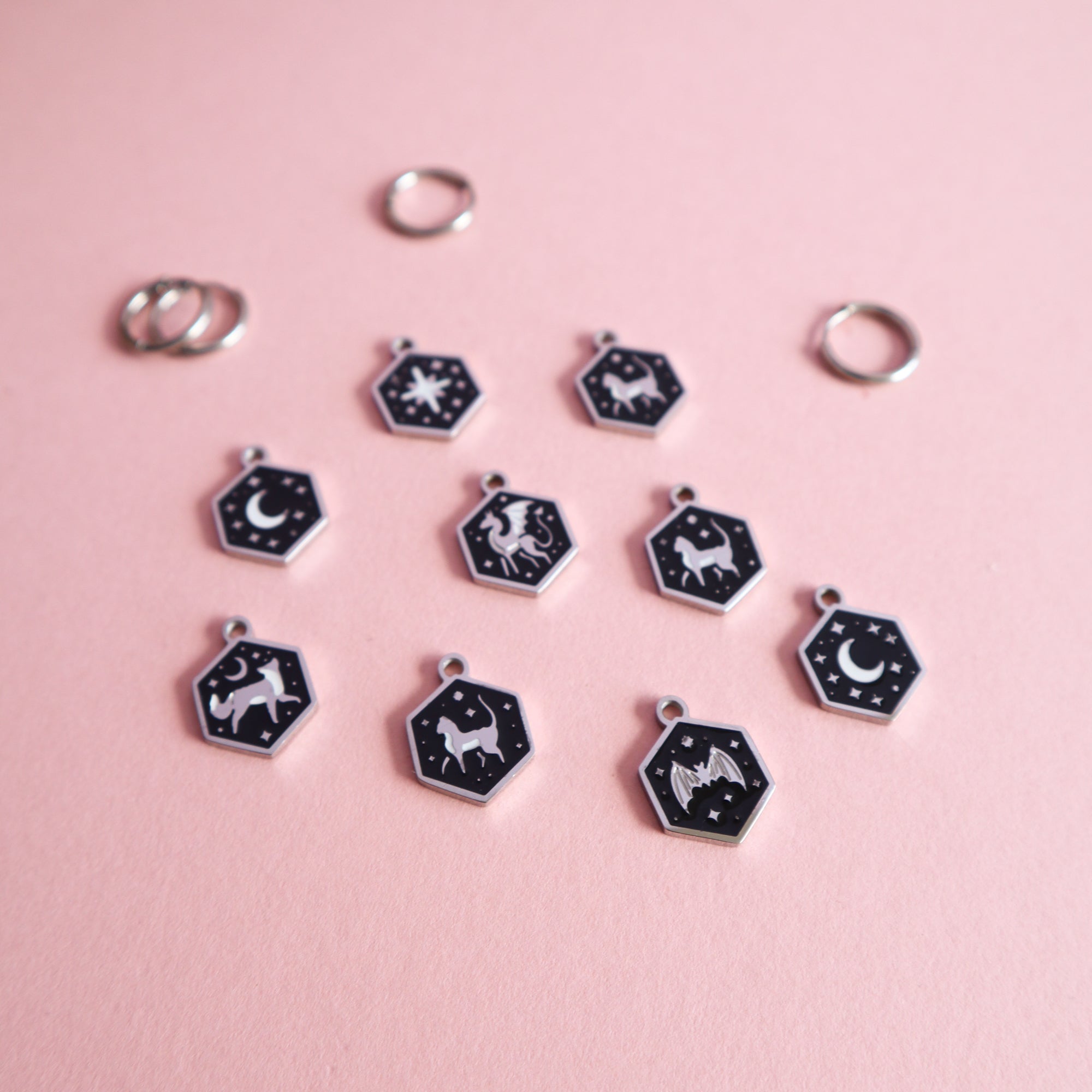 A selection of Papio Press seconds earrings on a light pink background.