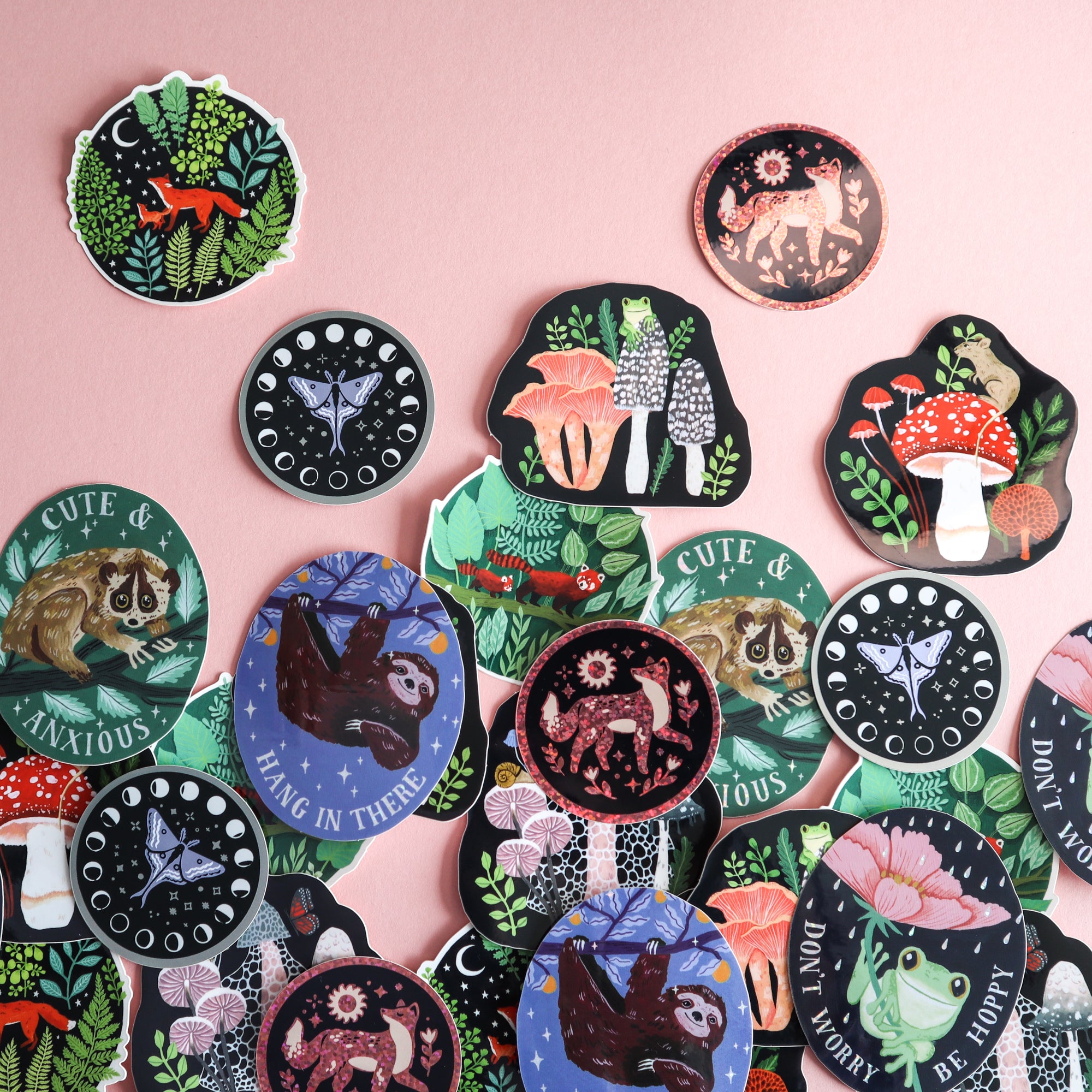 A selection of Papio Press stickers taken on a light pink background.