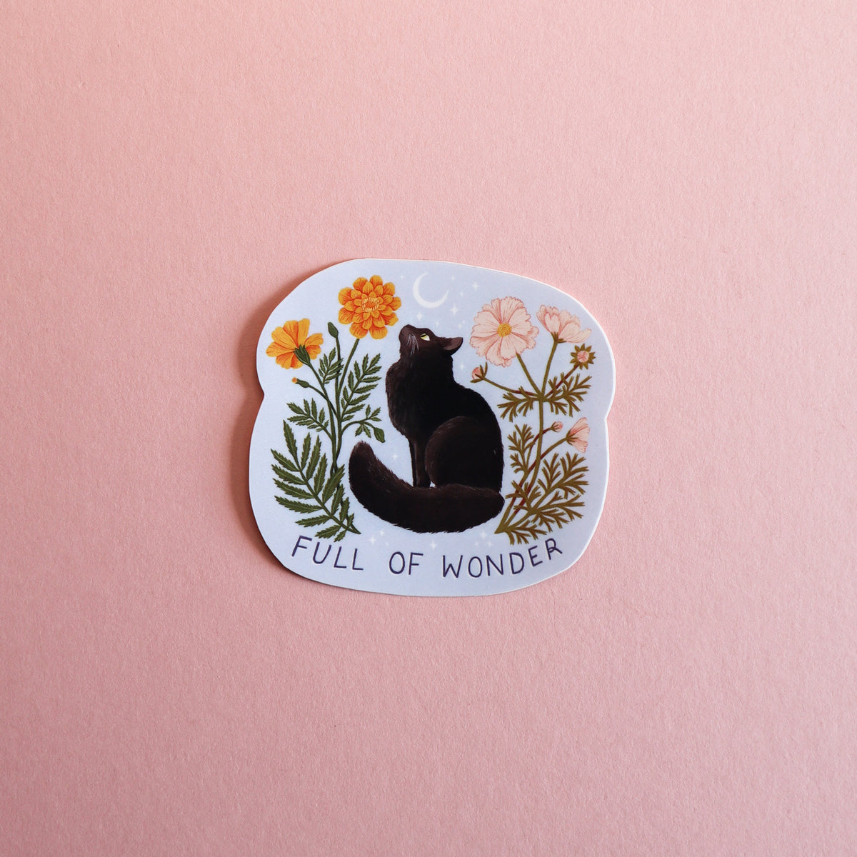 A die-cut sticker featuring a black cat sitting among orange and cream flowers on a pale blue background, with the text 'FULL OF WONDER' at the bottom, displayed on a solid pink surface.