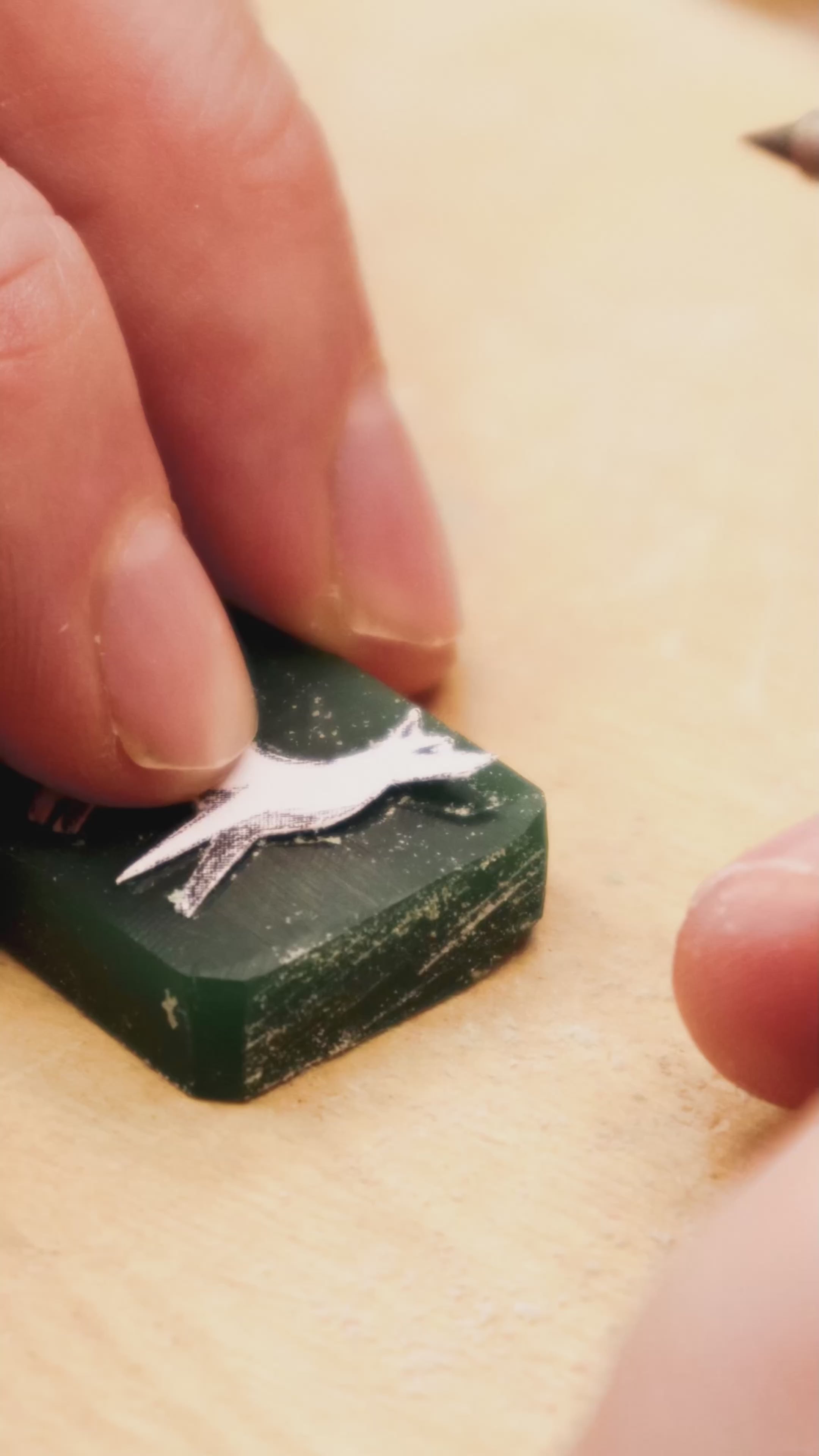 A video of a fox being carved from a block of green wax. First the design is scribed into the wax, then the excess wax is removed using a rotary tool. The design is the filed down and refined. Engraved details are added before the design is revealed in silver.