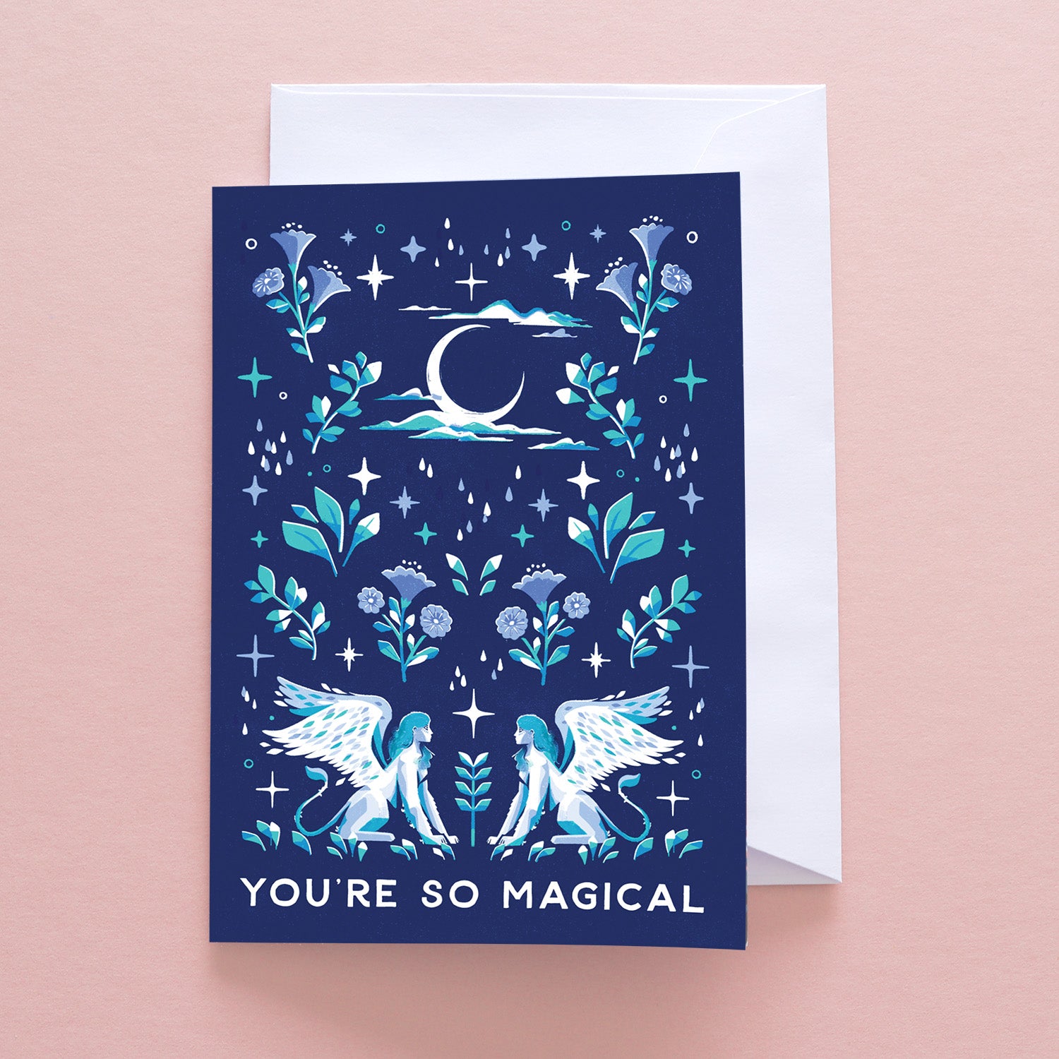 The Youre So Magical Sphynx Greetings Card by Papio Press features two winged sphynxes, flowers, stars, and a crescent moon on a blue recycled card with “YOU’RE SO MAGICAL” on the front. Envelope included.