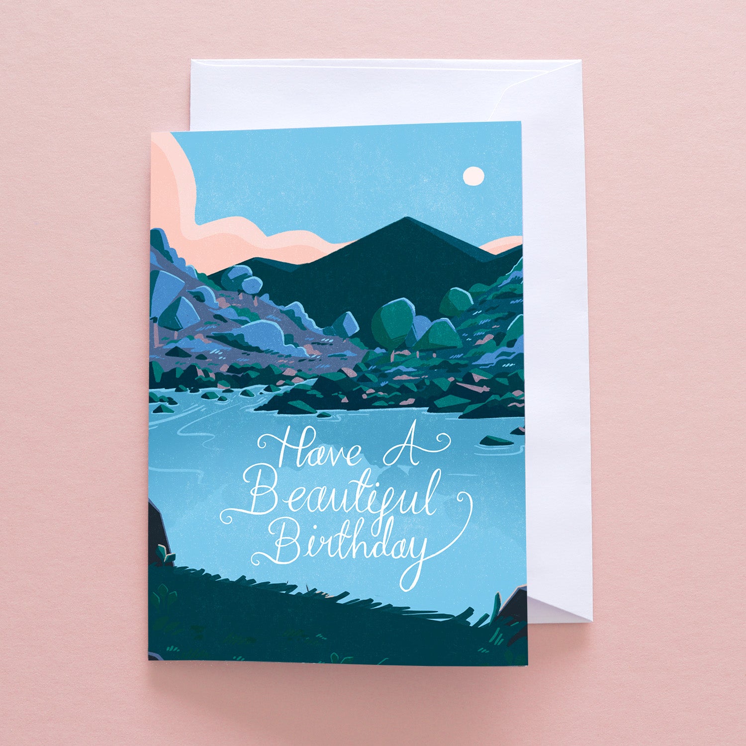 The Have A Beautiful Birthday Greetings Card by Papio Press features a mountain landscape, river, and pink clouds with an elegant script on recycled stock for an eco-friendly touch.