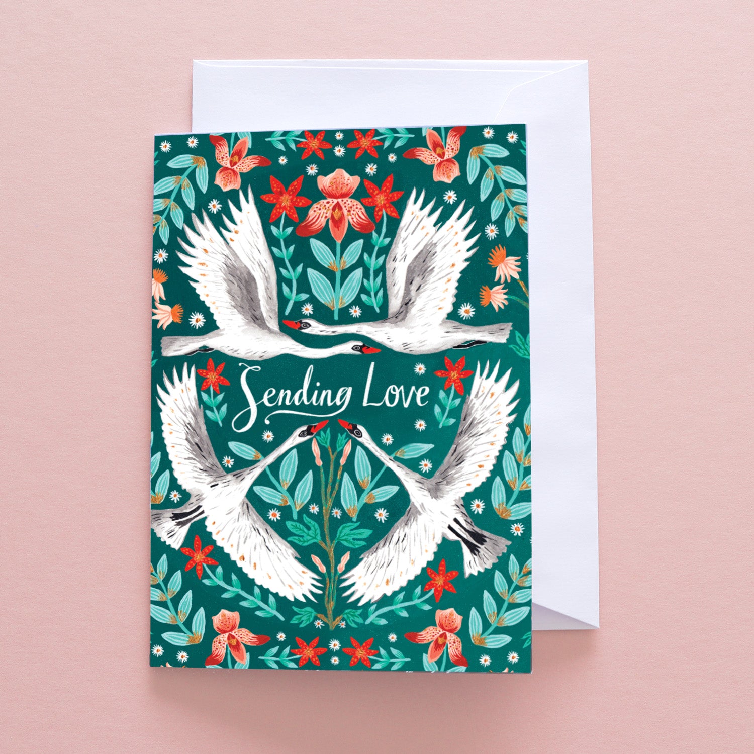 The With Love Swan Greetings Card by Papio Press features illustrated swans and red flowers on green, with Sending Love at the center. Supplied with an envelope, it’s printed on recycled stock.