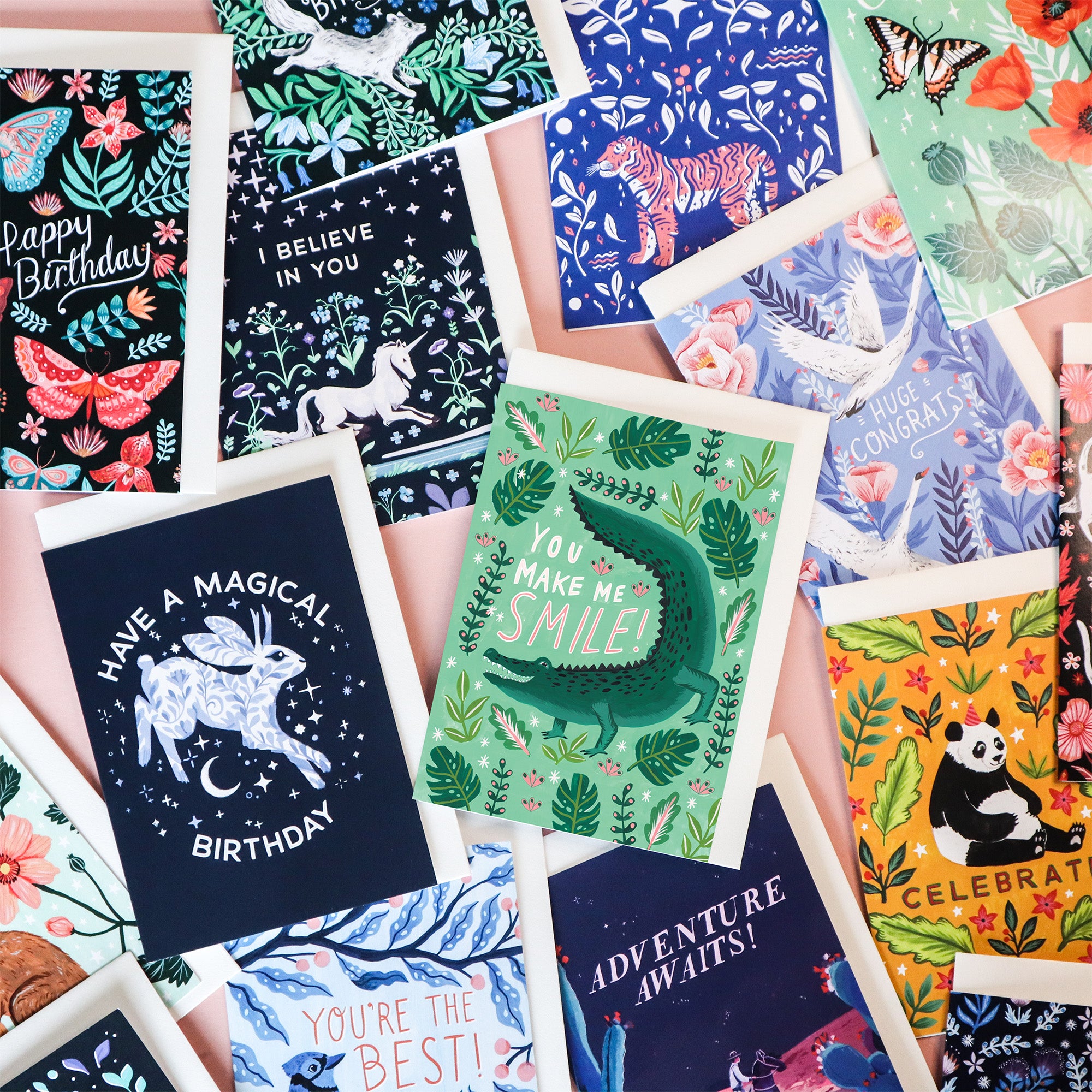 A selection of Papio Press Greetings cards on a pink background. It includes, Birthday, sympathy and love cards.